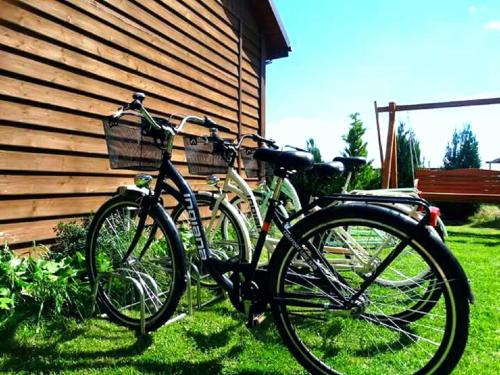 two bikes parked in the grass next to a building at Domki Letniskowe Lawenda in Rusinowo
