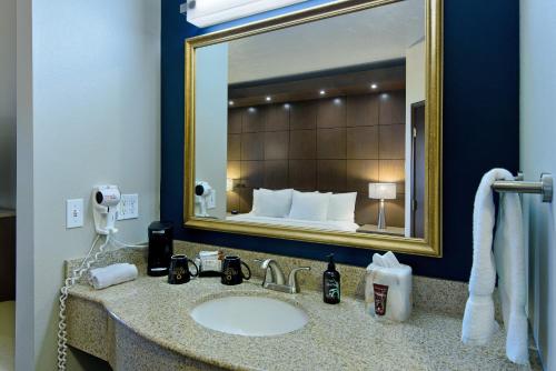 baño con lavabo y espejo grande en Oxford Suites Spokane Downtown en Spokane