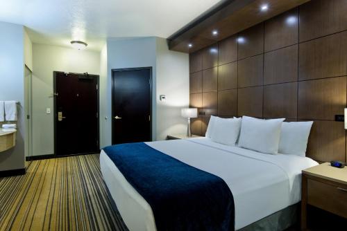 a hotel room with a large bed and a bathroom at Oxford Suites Spokane Downtown in Spokane