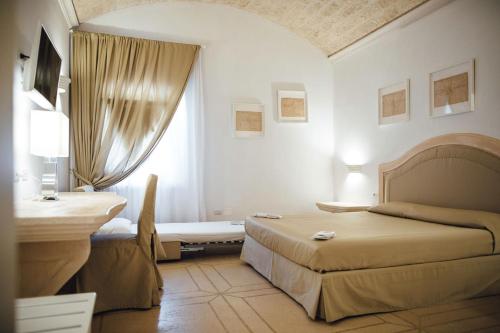 a bedroom with two beds and a desk and a window at La Magione in Foggia