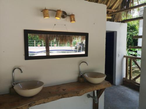 a bathroom with two sinks and a mirror at Hostal Mama Tayrona in Santa Marta
