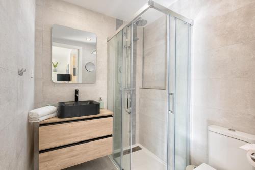 łazienka z przeszkloną kabiną prysznicową i umywalką w obiekcie Smart Malagueta Seaview w Maladze