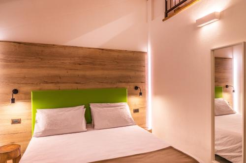 a bedroom with a bed with a green headboard at Hotel Folgarida in Folgarida