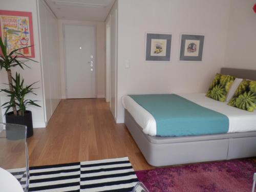 una camera da letto con un letto in una stanza di Ripple - Modern Condo with pool, aircon, parking a Lisbona