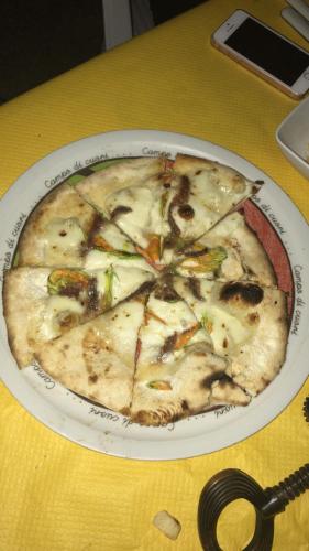 a pizza on a plate on a table at Valdipetrina Appartamenti in Città di Castello