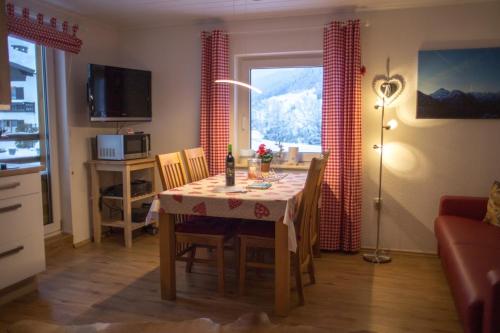 a living room with a table and a kitchen with a view at Almsternchen 2 - Almsternchen 3 in Oberstdorf