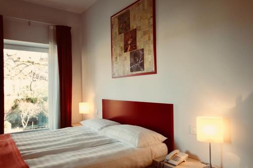 um quarto com uma cama e um telefone ao lado de uma janela em Hotel La Sosta em Cisano Bergamasco