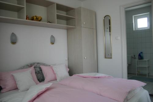 1 dormitorio con 1 cama grande con sábanas rosas en Doina Apartman, en Zalakaros