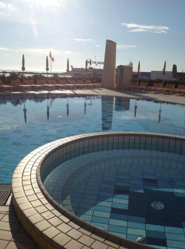 a large swimming pool with blue tiles on the ground at Hotel David in Cesenatico