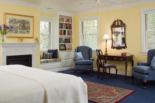 een slaapkamer met een bed, een bureau en stoelen bij The Inn at Whitewing Farm in West Chester