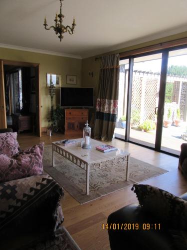 a living room with a coffee table and a television at Redwood Valley B & B in Richmond