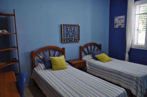 two beds in a room with blue walls at Villa Miramar, Güime in Güime