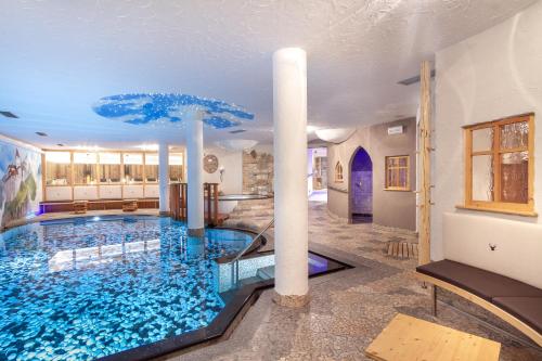 een groot zwembad in het midden van een kamer bij Hotel Madonnina Resort And Wellness in Soraga
