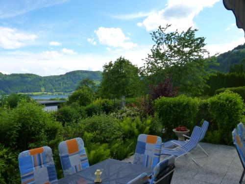 a table and chairs on a patio with a view of a river at Landhaus Monika in Bodensdorf