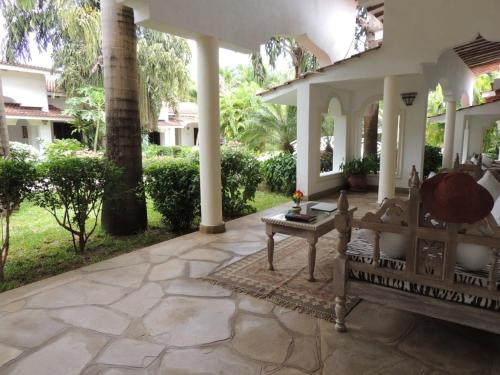 an outdoor patio with a bench and a table at Hotel Villa Malindi in Malindi