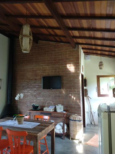 a living room with a table and a brick wall at Casa Vista da Lagoa in Gonçalves