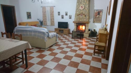 sala de estar con suelo a cuadros, cama y chimenea en Casa Rural Villa Rosa, en Écija