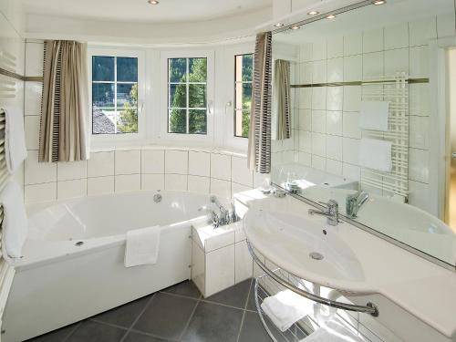 een witte badkamer met een bad en een wastafel bij Dolce Vita in Saas-Fee