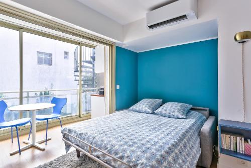 カンヌにあるStudio Cosy Pradignacの青いベッドルーム(ベッド1台、テーブル、椅子付)