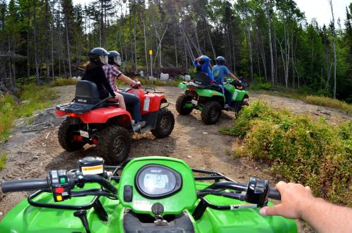 a group of people riding on motorcycles on a dirt road at Centre de Vacances 5 Étoiles Family Resort in Sacré-Coeur-Saguenay