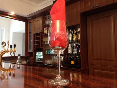 a wine glass with a red napkin on top of a bar at PENZION ANIKO GOLD *** in Horné Saliby