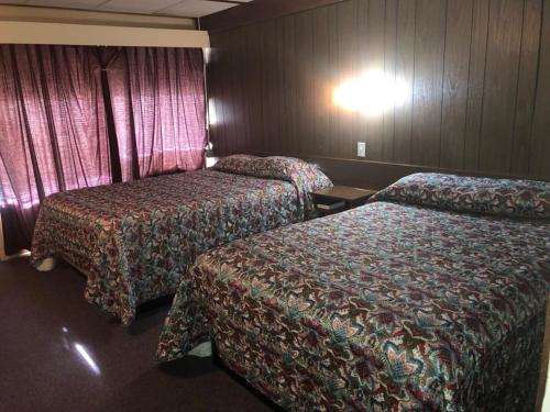 a hotel room with two beds and a light on the wall at Campbell Lodge in Glasgow