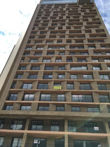 a tall building with a yellow sign on it at Enjoy In Bogotá in Bogotá