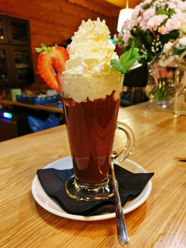 a drink with whipped cream and a strawberry on a table at Pokoje i Domki Na Szlaku in Polanica-Zdrój
