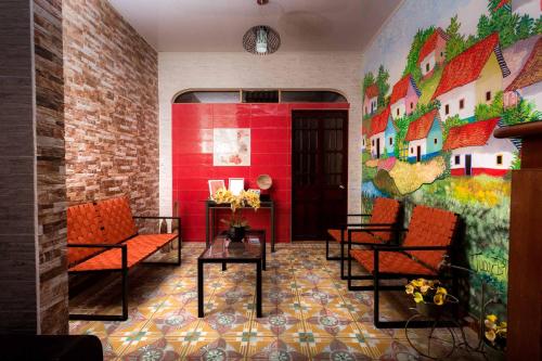 a room with chairs and a wall with a mural at Boutique Hotel Casa Orquídeas in San José