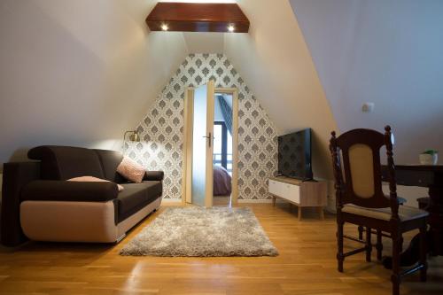 a living room with a couch and a chair at Apartamenty Ciche Wzgórze Zakopane in Zakopane