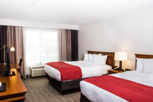 a hotel room with two beds and a desk at Country Inn & Suites by Radisson, Winchester, VA in Winchester