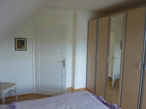 a bedroom with a bed and a closet and a door at Landhaus Monika in Bodensdorf