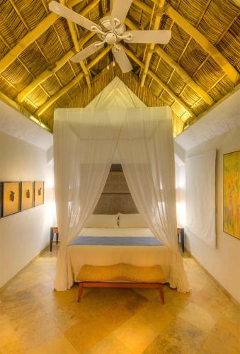 a bedroom with a bed with a ceiling fan at Mi Otra Casa in Sayulita