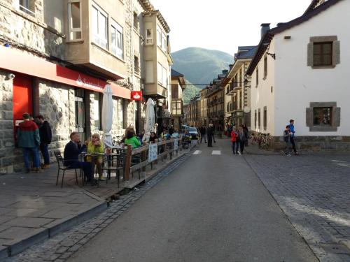 a group of people sitting at tables on a street at Best Biescas Tourist Home in Biescas