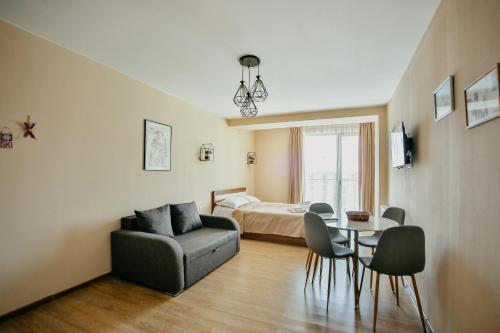 a living room with a couch and a table and a bed at Maisako's New Gudauri Apartment in Gudauri