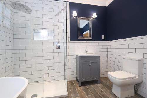 a bathroom with a toilet and a sink and a mirror at Dollar Apartments-41 Bridge Street in Dollar