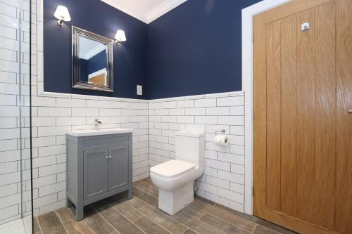 a bathroom with a toilet and a sink and a mirror at Dollar Apartments-41 Bridge Street in Dollar