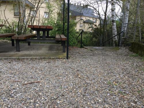 a picnic table and a bench in a park at Best Biescas Tourist Home in Biescas