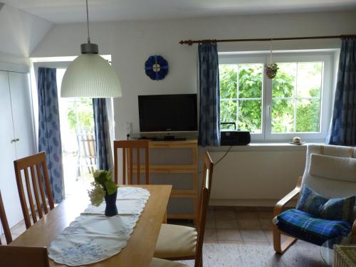 a living room with a dining room table and a kitchen at Landhaus Monika in Bodensdorf