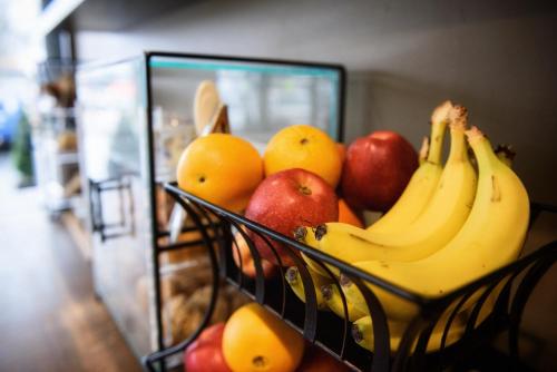 a basket of fruit with apples oranges and bananas at Georgetown Inn Seattle in Seattle