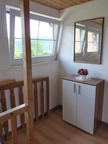 a room with two windows and a small white cabinet at Landhaus Monika in Bodensdorf