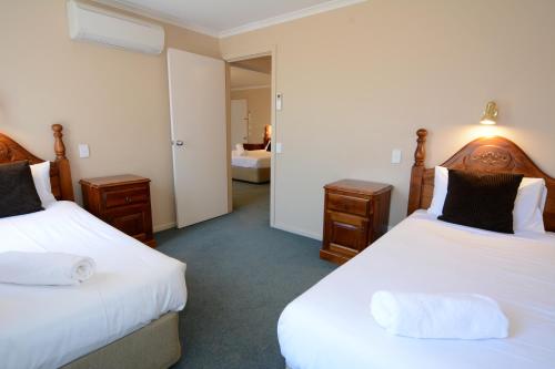 a hotel room with two beds and a mirror at City Centre Motel in Bendigo