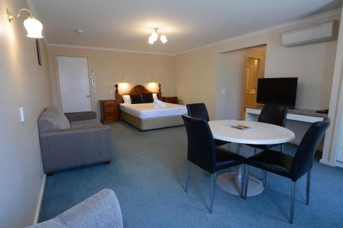 a hotel room with a bed and a table and chairs at City Centre Motel in Bendigo