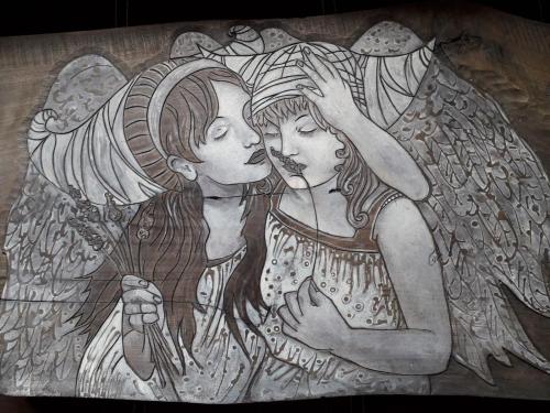 a drawing of two angels on a wall at Domki i Apartamenty Rogate Anioły in Wetlina