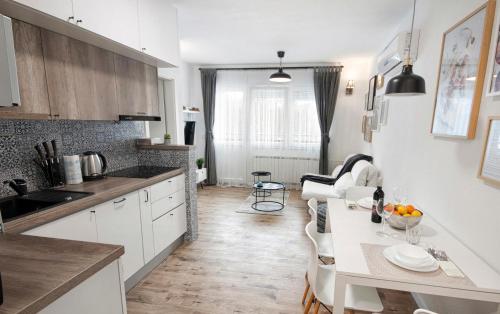 a kitchen with a table and a dining room at L&L Leisure Apartments Plitvice in Plitvička Jezera