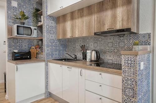 a kitchen with white cabinets and a microwave at L&L Leisure Apartments Plitvice in Plitvička Jezera
