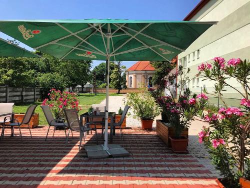 a patio with a table and a green umbrella at PENZION ANIKO GOLD *** in Horné Saliby