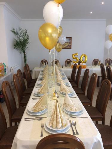 a long table with plates and balloons on it at PENZION ANIKO GOLD *** in Horné Saliby