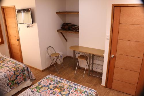 a bedroom with a desk and a bed and a table at Hostal Luna del Mar 840-B in La Serena