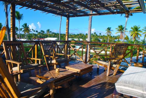 a patio area with chairs, tables and umbrellas at ECOHOSTAL Dorms mixt Dormitorios in Punta Cana